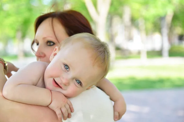 Madre felice che tiene in braccio il suo adorabile figlioletto. Famiglia outdoor lei — Foto Stock