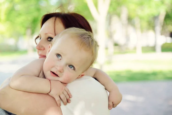 Madre felice che tiene in braccio il suo adorabile figlioletto. Famiglia outdoor lei — Foto Stock