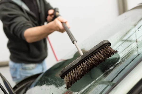 Mytí aut. Muž čištění vozu pomocí vysokého tlaku vody a brus — Stock fotografie