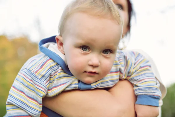 Feliz madre sosteniendo a su adorable hijito. Familia lei al aire libre —  Fotos de Stock