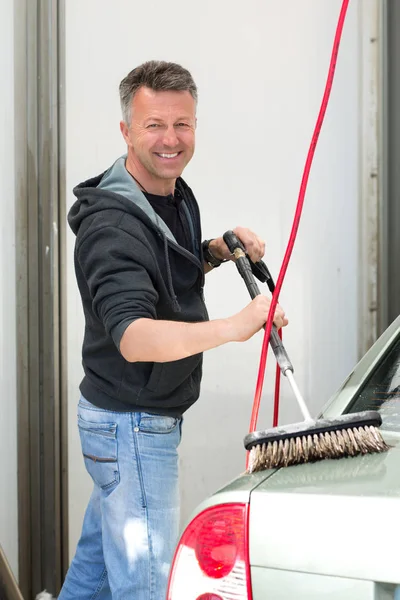 Auto wassen. Man reinigen van de auto met behulp van hogedruk water en brus — Stockfoto