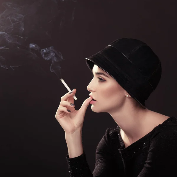 Junge Modefrau raucht Zigarette mit Hut und schwarzem Drees ove — Stockfoto