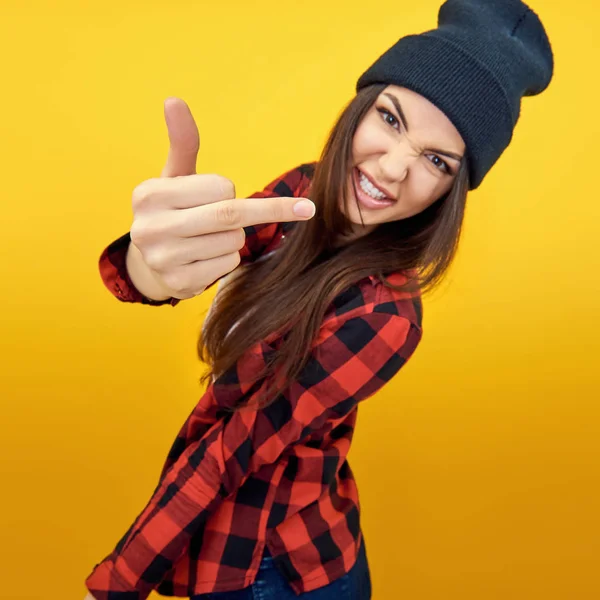 Hipster chica en jeans, camisa a cuadros y sombrero mostrando el medio f —  Fotos de Stock