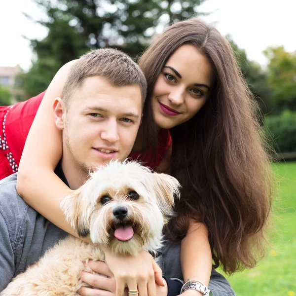 Genç köpek yavrusu ile çift. Çekici mutlu yo gülümseyen portresi — Stok fotoğraf