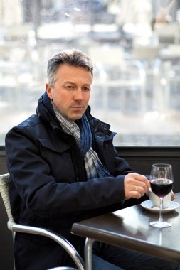 Yakışıklı adam sokak kış kafede kahve ve şarap içme. Erkek