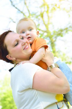 Sevimli küçük oğlu tutan mutlu anne. Aile açık lei