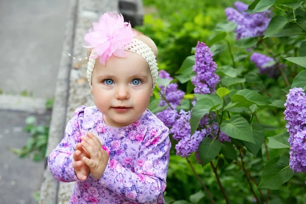 Krásná holčička šťastný úsměv a tleská rukama nad lil — Stock fotografie