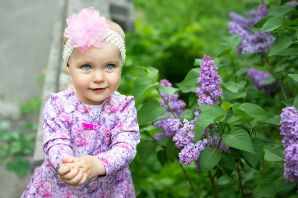 Krásná holčička šťastný úsměv a tleská rukama nad lil — Stock fotografie