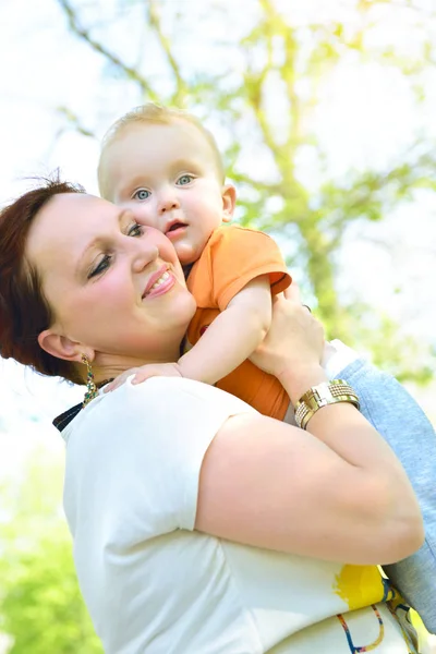 Szczęśliwą matką, trzymając jej adorable synka. Lei świeżym powietrzu dla rodzin z dziećmi — Zdjęcie stockowe