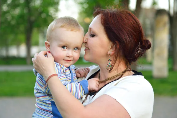 Happy mother holding her adorable little son. Family outdoor lei — Stock Photo, Image