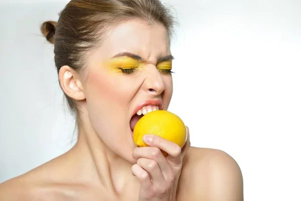 Young attractive girl posing at studio with lemon. Beautiful fem — Stock Photo, Image
