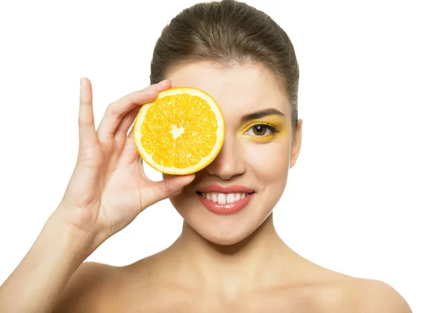 Молодая счастливая улыбчивая женщина с половинкой апельсина в руках — стоковое фото