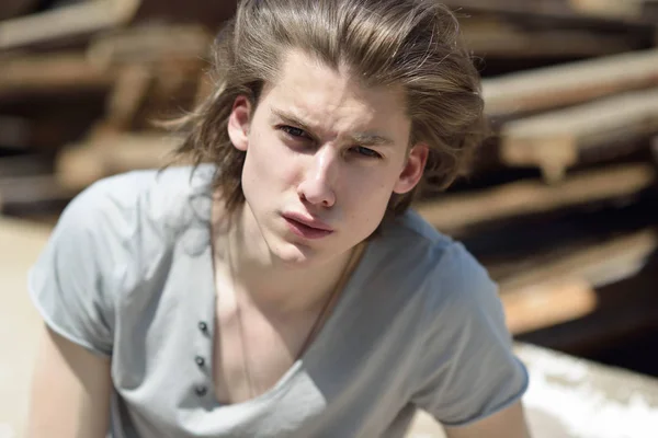 Retrato de homem bonito jovem sobre tábuas de madeira, ao ar livre. Attrac — Fotografia de Stock