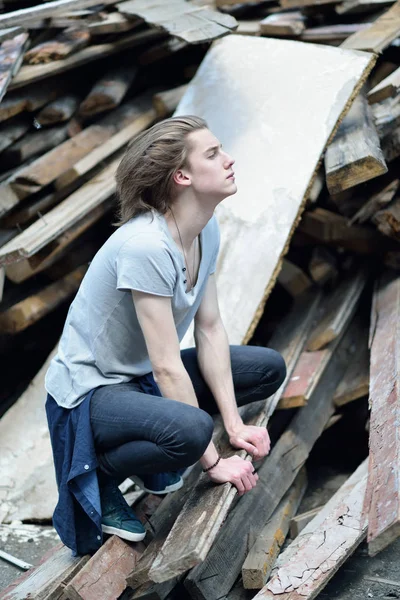 Retrato de un joven guapo sobre tablas de madera, al aire libre. Attrac —  Fotos de Stock