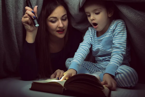 小さな女の子と彼女の母親は、おとぎ話を読んで予約 co 下 — ストック写真