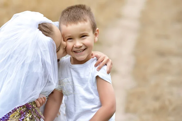 Junge Braut und Bräutigam spielen Hochzeit Sommer im Freien. Kinder l — Stockfoto