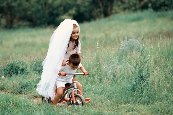 Mladá nevěsta a ženich hraje svatební letní venkovní. Děti l — Stock fotografie