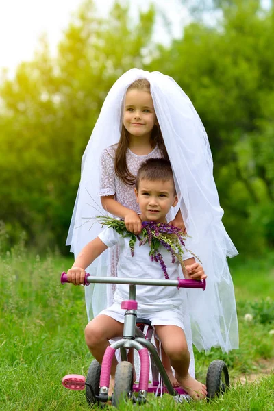 Mladá nevěsta a ženich hraje svatební letní venkovní. Děti l — Stock fotografie