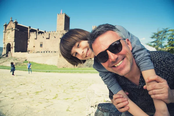 Far och son poserar och leende över spanska fornborg Ja — Stockfoto