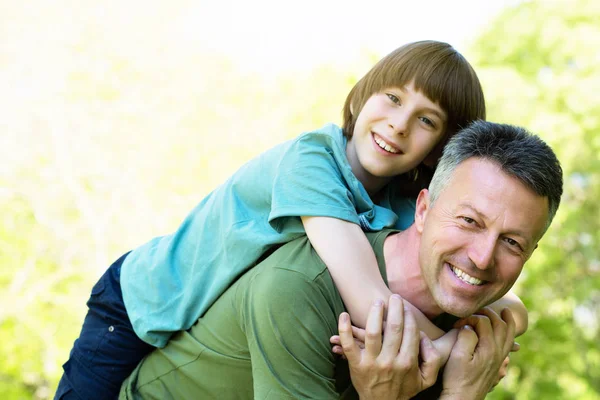 Portrait de père avec son fils s'amusant dans un parc d'été. Piggy ! — Photo