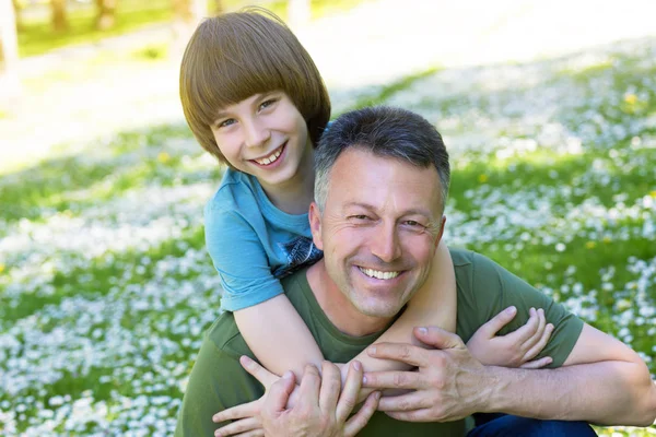 Portret van vader met zijn zoon plezier in zomer park. Piggy — Stockfoto