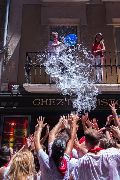 Människor firar San Fermin-festivalen i traditionella vita abd re — Stockfoto