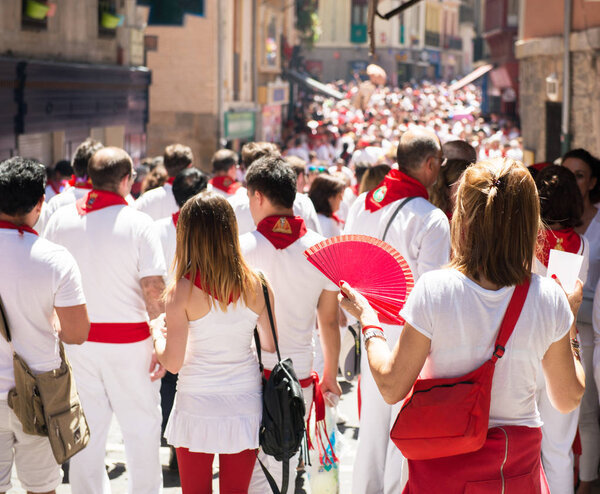 People celebrate San Fermin festival in traditional white abd re