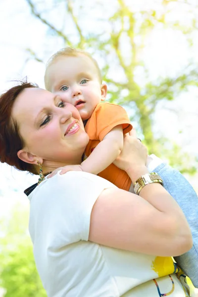 Happy mother holding her adorable little son. Family outdoor lei Stock Picture