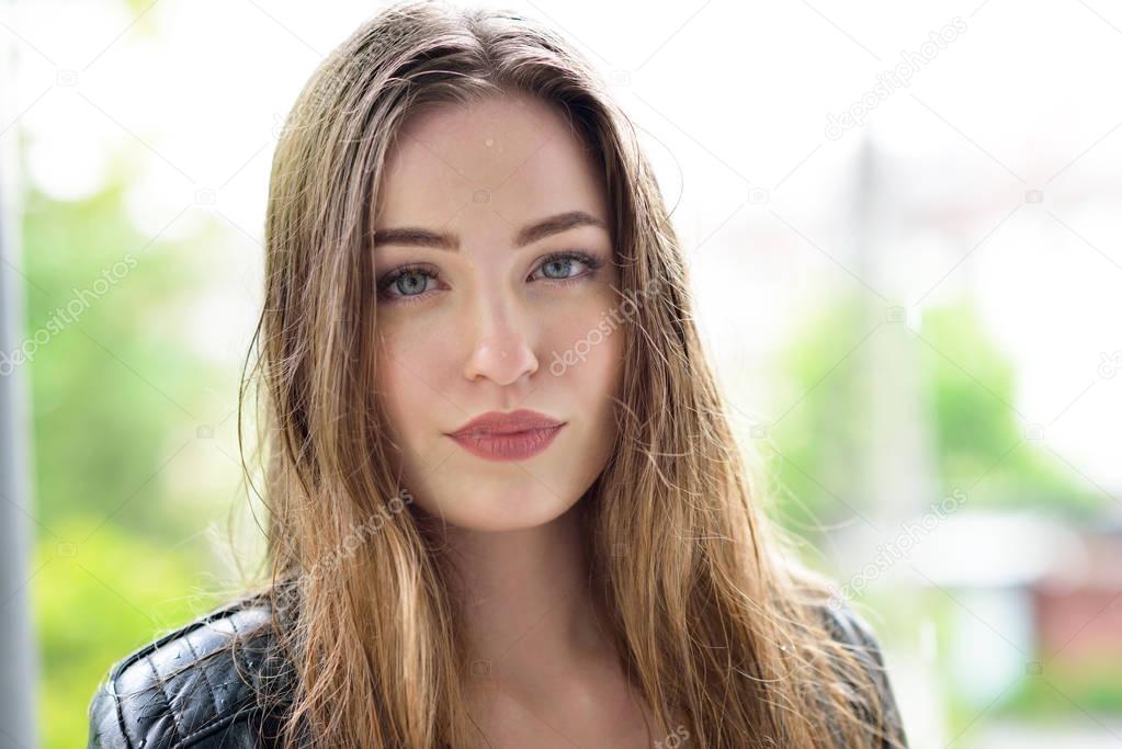 Young attractive woman standing in the rain directing her face t