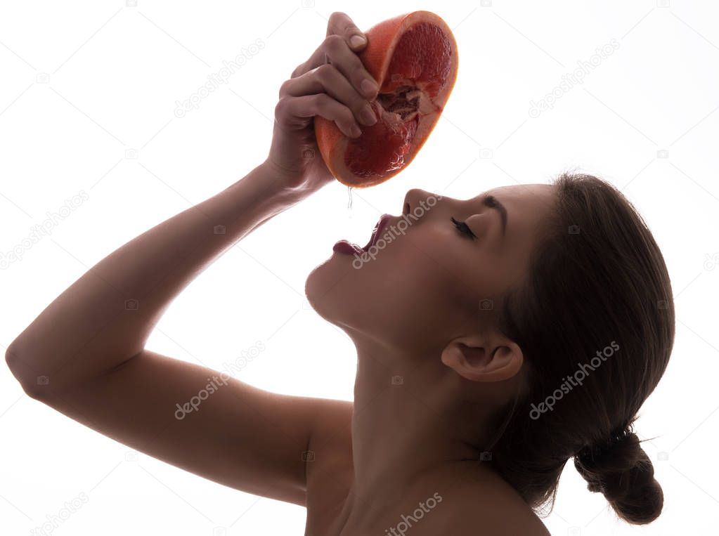 Young attractive girl posing at studio with ripe grapefruit. You