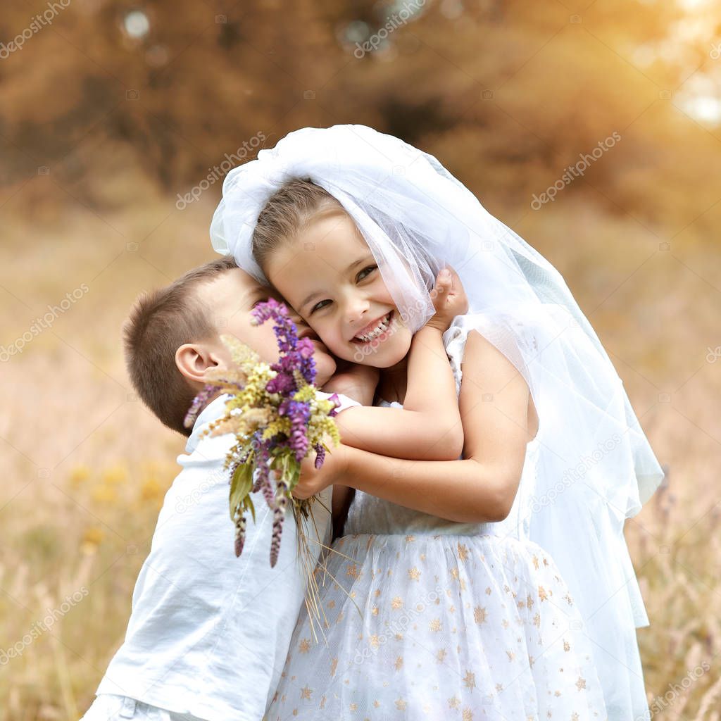 Young bride and groom playing wedding summer outdoor. Children l