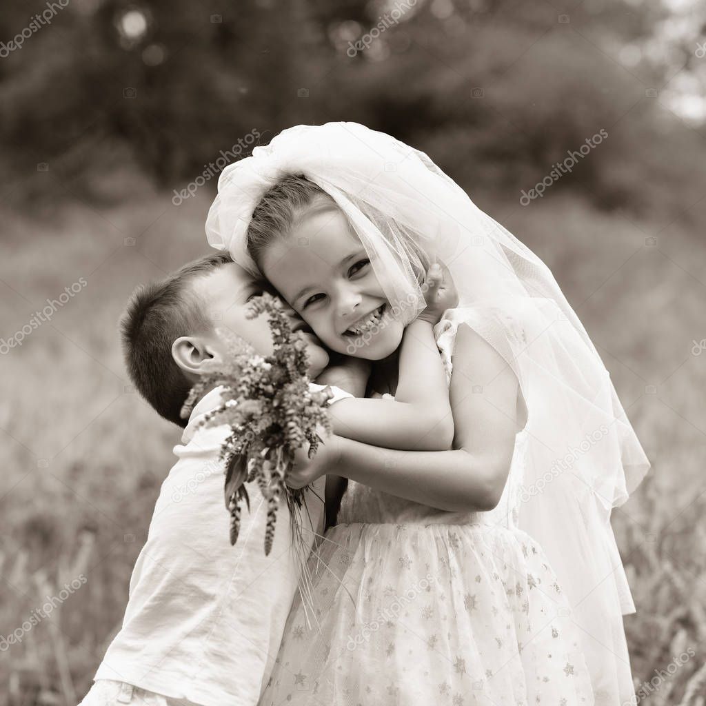 Young bride and groom playing wedding summer outdoor. Children l