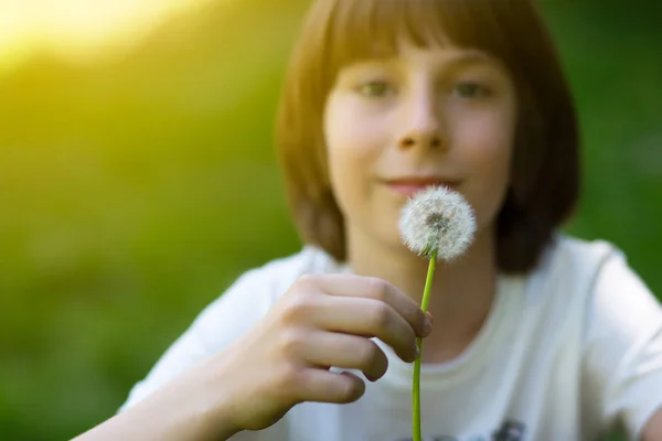 Мальчик с одуванчиком над размытой зеленой травой, летняя природа outdoo — стоковое фото