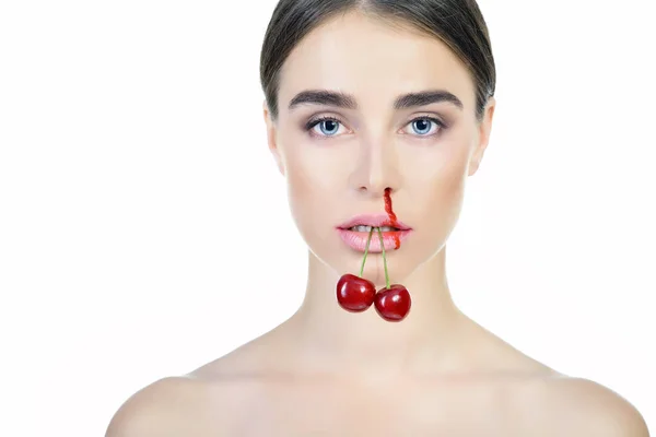 Young beautiful woman with ripe cherry bleeding nose. Anti-glamo — Stock Photo, Image