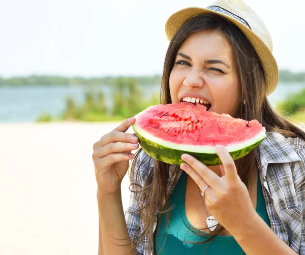 Gelukkig jonge vrouw watermeloen te eten op het strand. Jeugd lifestyl — Stockfoto