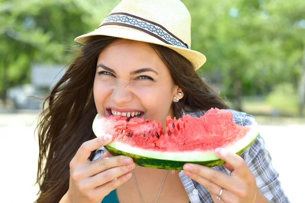 Šťastná mladá žena jíst meloun na pláži. Životní styl mládeže — Stock fotografie