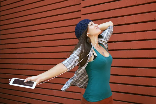 Chica divertida escuchando la música con auriculares de un ph inteligente —  Fotos de Stock