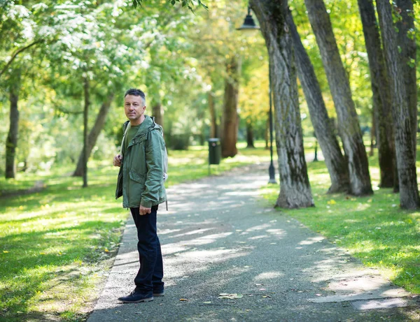 Przystojny mężczyzna w średnim wieku spaceru w parku jesień — Zdjęcie stockowe