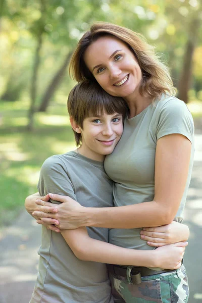 Mãe feliz e seu 11 anos lindo filho está abraçando outdoo — Fotografia de Stock