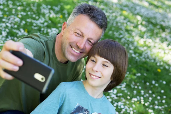 父亲和儿子一起拍照与智能手机一起户外 家庭自拍时间 — 图库照片