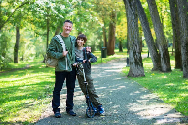 彼の息子と一緒に秋の公園を歩いて父親の肖像画 家族のレジャー 子育て 画像トーンとノイズが追加されました — ストック写真