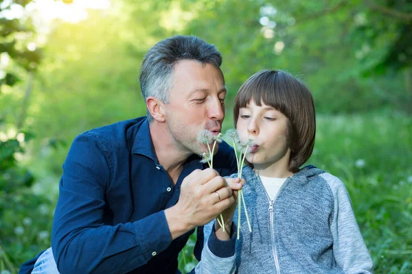 Mann Mit Sohn Bläst Löwenzahn Über Verschwommenes Grünes Gras Sommer — Stockfoto