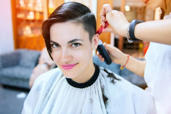 Beauty, hairstyle, treatment, hair care concept, young woman and hairdresser cutting hair at hairdressing salon. Hairdresser cutts beautiful happy girl\'s hair. Hairstylist serving client at barber shop. Professional barber doing hairstyle in barbersh