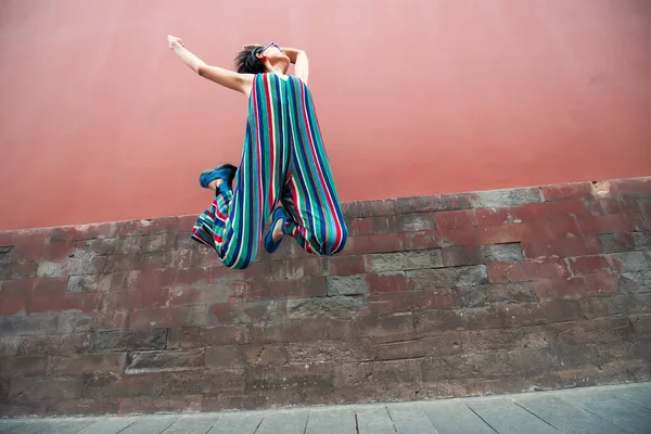 Молодая Привлекательная Женщина Прыгает Открытом Воздухе Через Красную Стену Изображение — стоковое фото