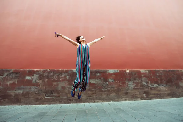 Mujer Atractiva Joven Saltando Aire Libre Sobre Pared Roja Imagen —  Fotos de Stock