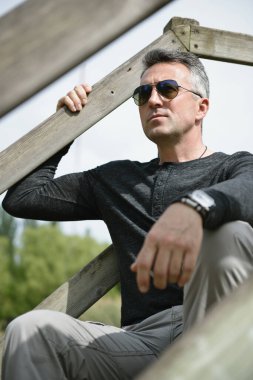 Yakışıklı bir adam. Açık hava erkek portresi. Bahar parkında poz veren bekar, güzel bir adam.