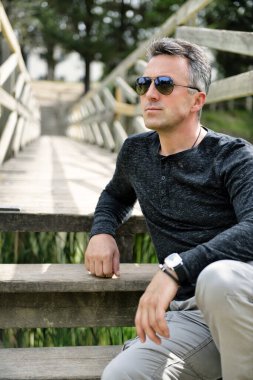 Yakışıklı bir adam. Açık hava erkek portresi. Bahar parkında poz veren bekar, güzel bir adam.