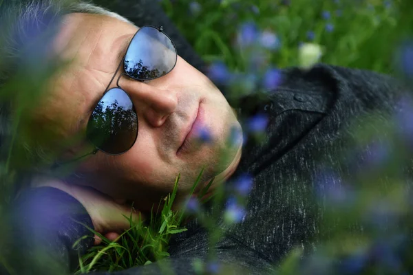 Retrato Homem Meia Idade Bonito Deitado Campo Entre Flores Azuis — Fotografia de Stock