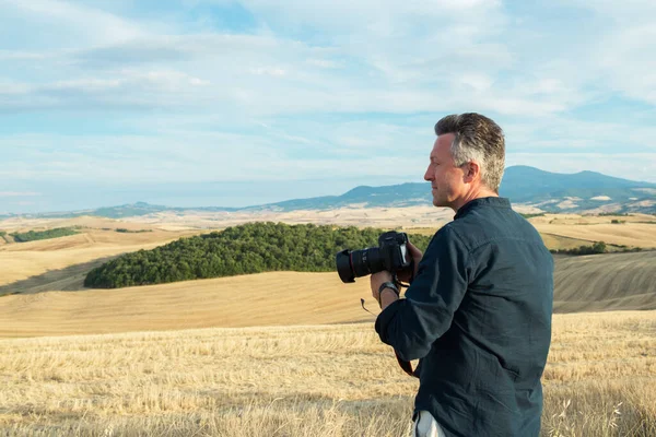 Człowiek Profesjonalny Fotograf Aparatem Cyfrowym Spaceruje Polach Toskanii Robi Zdjęcia — Zdjęcie stockowe