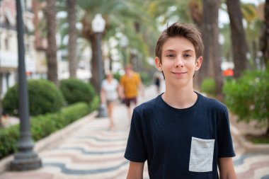 Yakışıklı çocuk Alicante panoramasından kameraya bakıyor. İspanya 'nın Akdeniz kıyısında gülümseyen güzel bir genç çocuk. Seyahat, yaz tatili, turizm, gençlik yaşam tarzı.